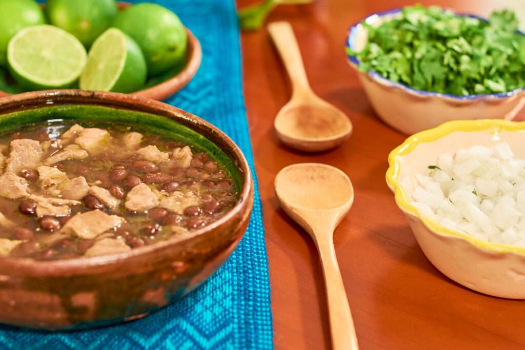 carne en su jugo served in clay plate on wooden table. mexican f